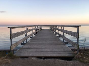 Wooden pier on sea during sunset