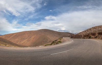 Road by mountain against sky