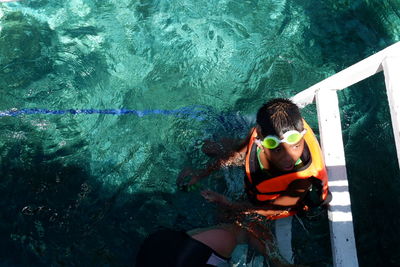 High angle view of boy swimming in sea