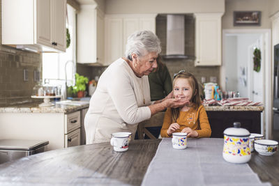 Granddaughter and great grandmother at kitchen table
