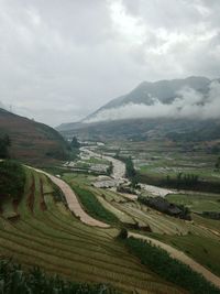 Scenic view of mountains against cloudy sky