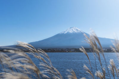 Scenic view of snowcapped mountains against clear blue sky