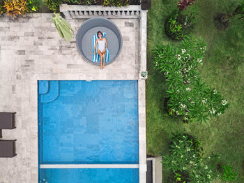 Aerial view of attractive woman near the pool at resort