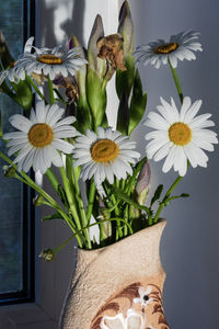 A beautiful bouquet of wildflowers, daisies and toffee in a vase.