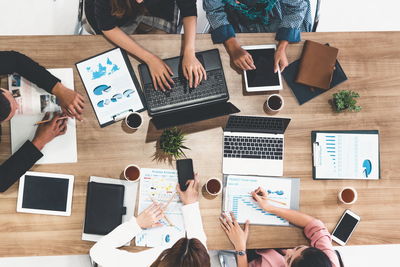 High angle view of people using laptop on table