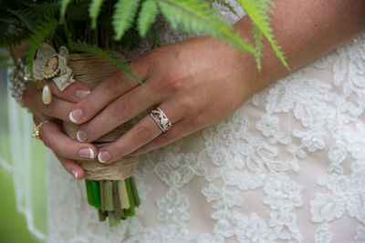 Midsection of bride holding bouquet