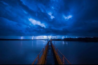 Scenic view of sea against cloudy sky at night