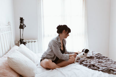 Young woman sitting on bed