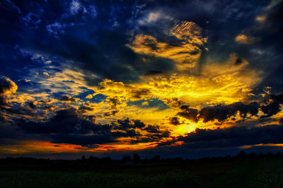 Scenic view of dramatic sky over land during sunset