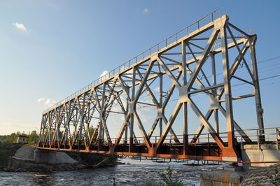 Low angle view of bridge over river against sky
