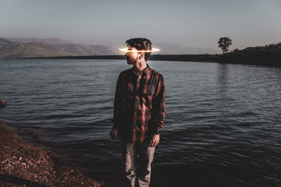 Full length of boy standing in sea against sky