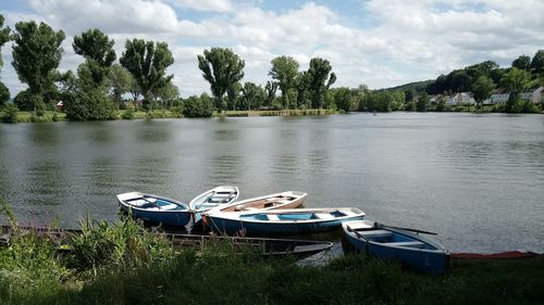 Boats moored in lake against sky