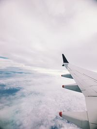 Airplane flying over cloudscape against sky