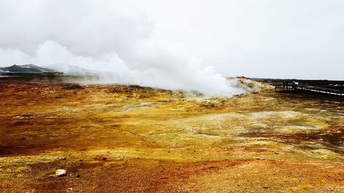 Smoke emitting from volcanic mountain against sky