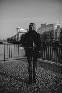 Rear view of woman walking on footpath