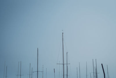 Low angle view of masts against clear blue sky