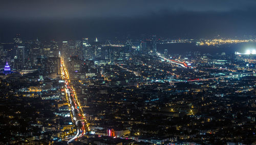 Illuminated cityscape against sky at night