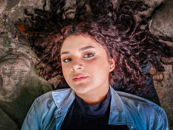 Portrait of beautiful young woman with tree trunk