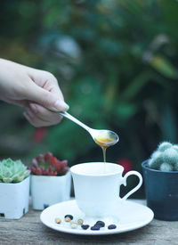 Hand holding coffee cup on table