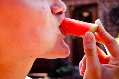 Close-up midsection of person eating watermelon slice