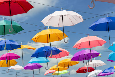 Low angle view of umbrellas hanging against sky