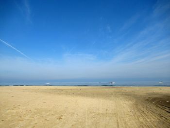 Scenic view of beach against blue sky