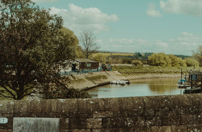 Scenic view of river by buildings against sky