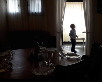 Man and woman standing by window at home