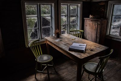 Empty chairs by table and window at home