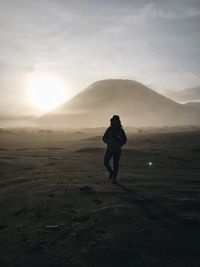 Full length of silhouette man on mountain against sky during sunset