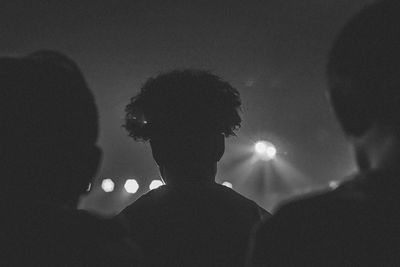 Rear view of silhouette people standing at night