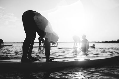 Men standing on beach against sky