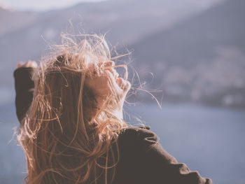 Side view of woman with blond frizzy hair