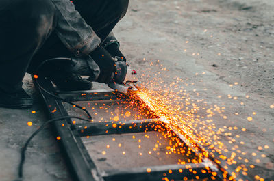 Low section of man working on metal