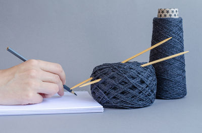 Close-up of hand holding pencils on table