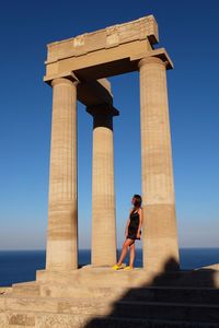 Low angle view of woman standing against the sky