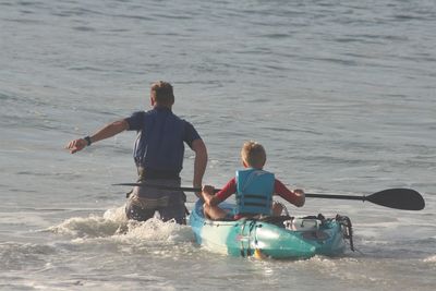 Full length of father and son on sea