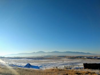 Scenic view of beach against clear blue sky