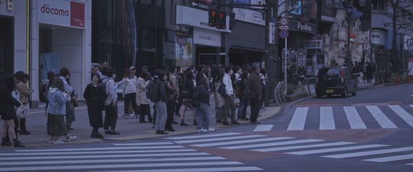 Group of people crossing road in city