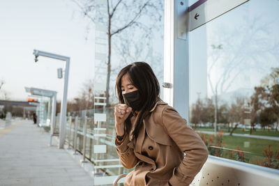 Portrait of young woman standing in city