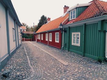 Street amidst houses and buildings against sky