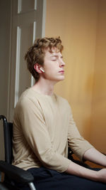 Mid adult man looking away while sitting at home