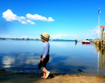 Rear view of man on beach against sky