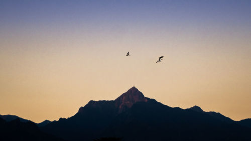 Low angle view of silhouette mountain against clear sky