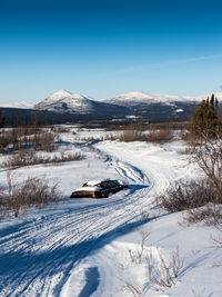 Snow covered landscape against sky