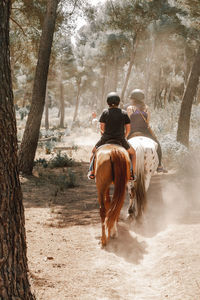 Rear view of woman standing in forest