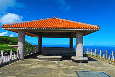 Gazebo by sea against blue sky