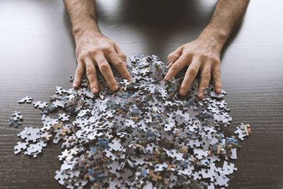 Cropped hands with puzzles at table