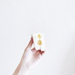 Woman holding ice cream cone against white background