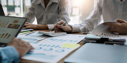 Midsection of business people working at office
